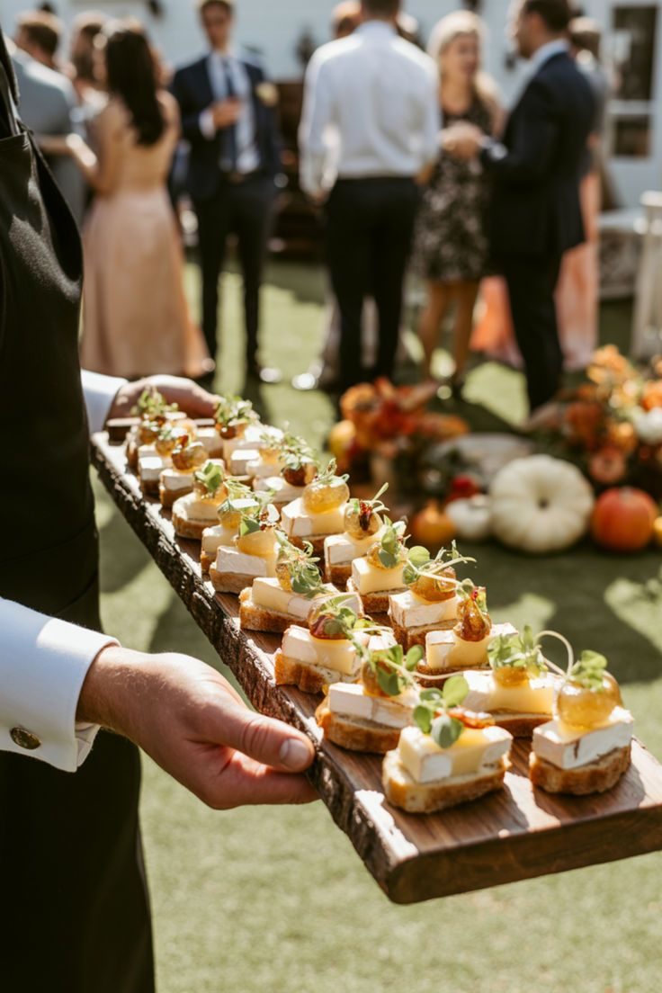 Cameriere con vassoio di crostini al formaggio durante un ricevimento all'aperto